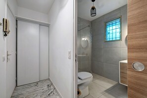 A bathroom with a toilet, a shower, and a window. - Apartment 'Studio Nice' with Shared Pool, Wi-Fi and Air Conditioning (Nice)