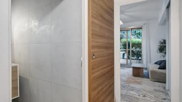 A modern interior with a wooden door leading to a living area with a sofa and a coffee table.