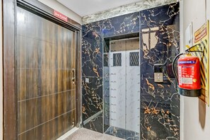 An elevator with a fire extinguisher mounted on the wall and a sign indicating the 2nd floor. - Hotel O Noida premium inn (Noida)