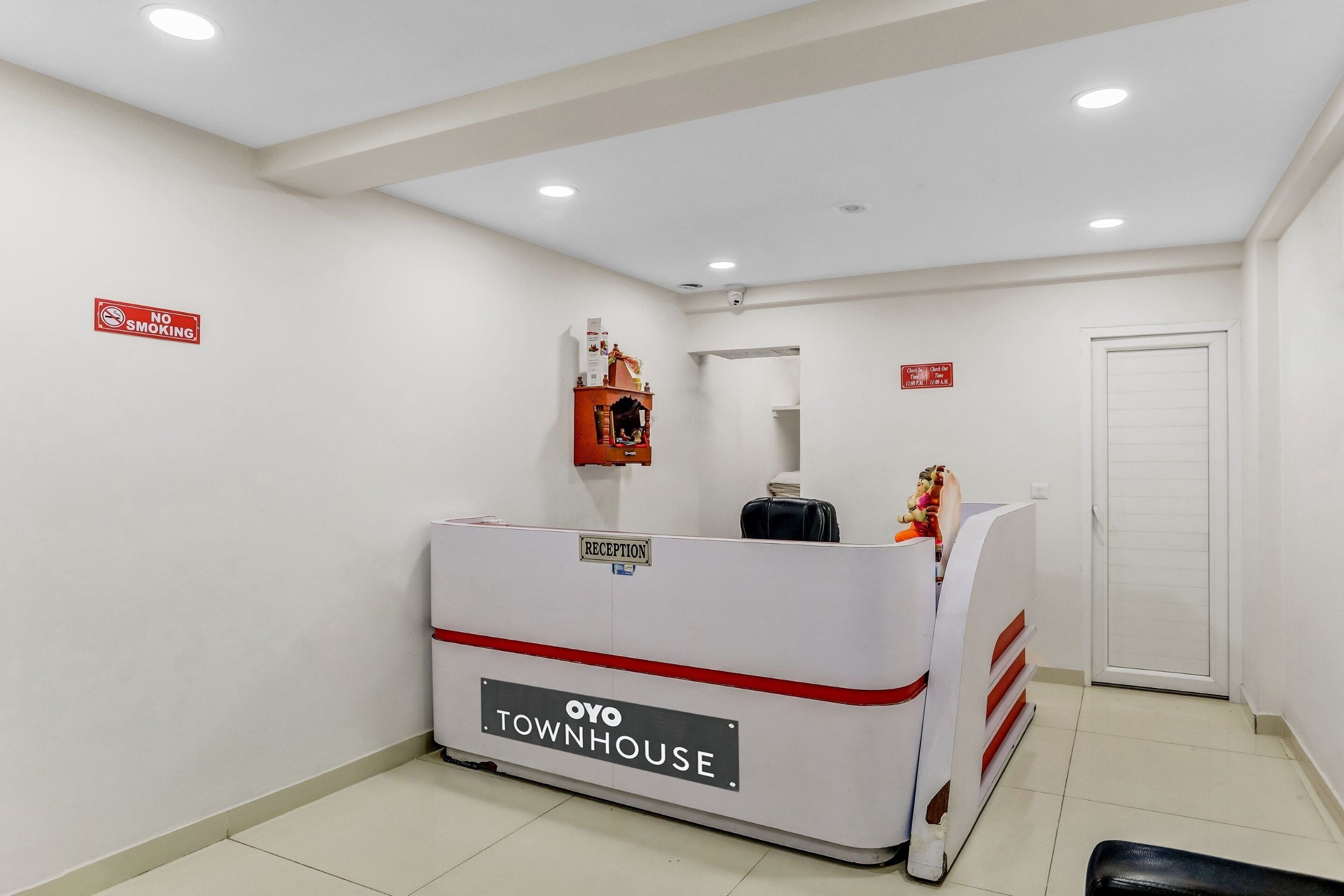 A reception desk labeled 'OYO TOWNHOUSE' with a 'NO SMOKING' sign on the wall.
