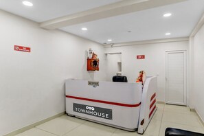 A reception desk labeled 'OYO TOWNHOUSE' with a 'NO SMOKING' sign on the wall. - Hotel O Noida premium inn (Noida)
