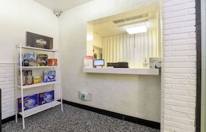 A reception area with a white brick wall, a reception desk with a computer and a telephone, and a shelf with board games. - The Stay Nangman Taejeon (Daegu)