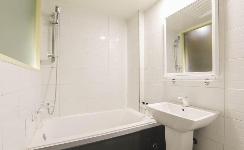 A bathroom with a bathtub, a sink, and a shower.
