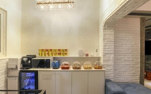 A kitchenette with a microwave, coffee maker, and a refrigerator. There are snack containers on the counter. - The Stay Nangman Taejeon (Daegu)