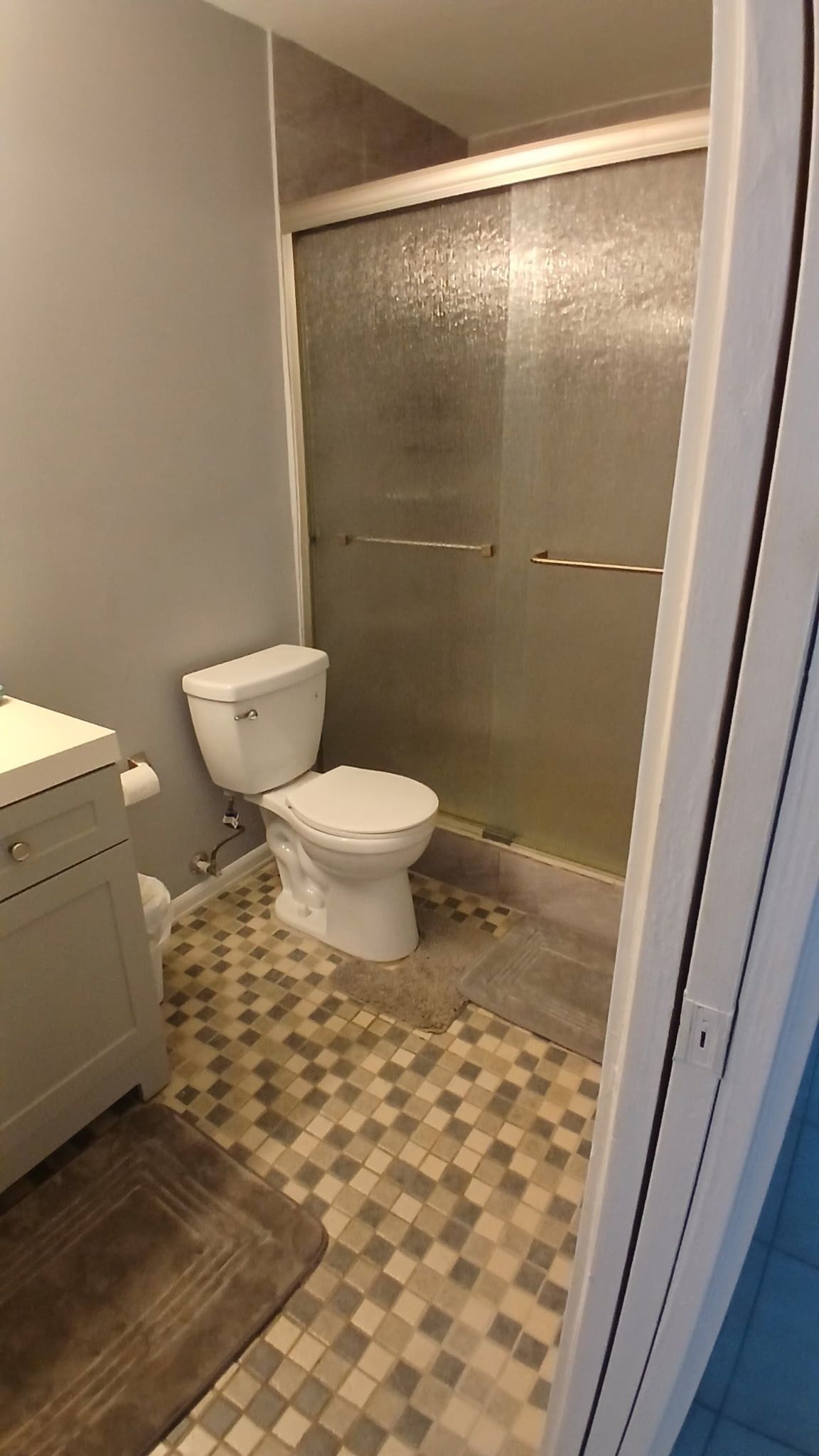 A bathroom with a toilet, a shower, and a sink.