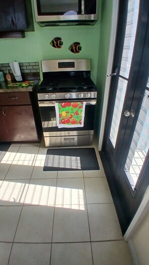 Cocina compacta con estufa, horno y microondas.