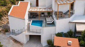 Ein mehrstöckiges Wohngebäude mit Schwimmbad, Außenbereich und einer Treppe.