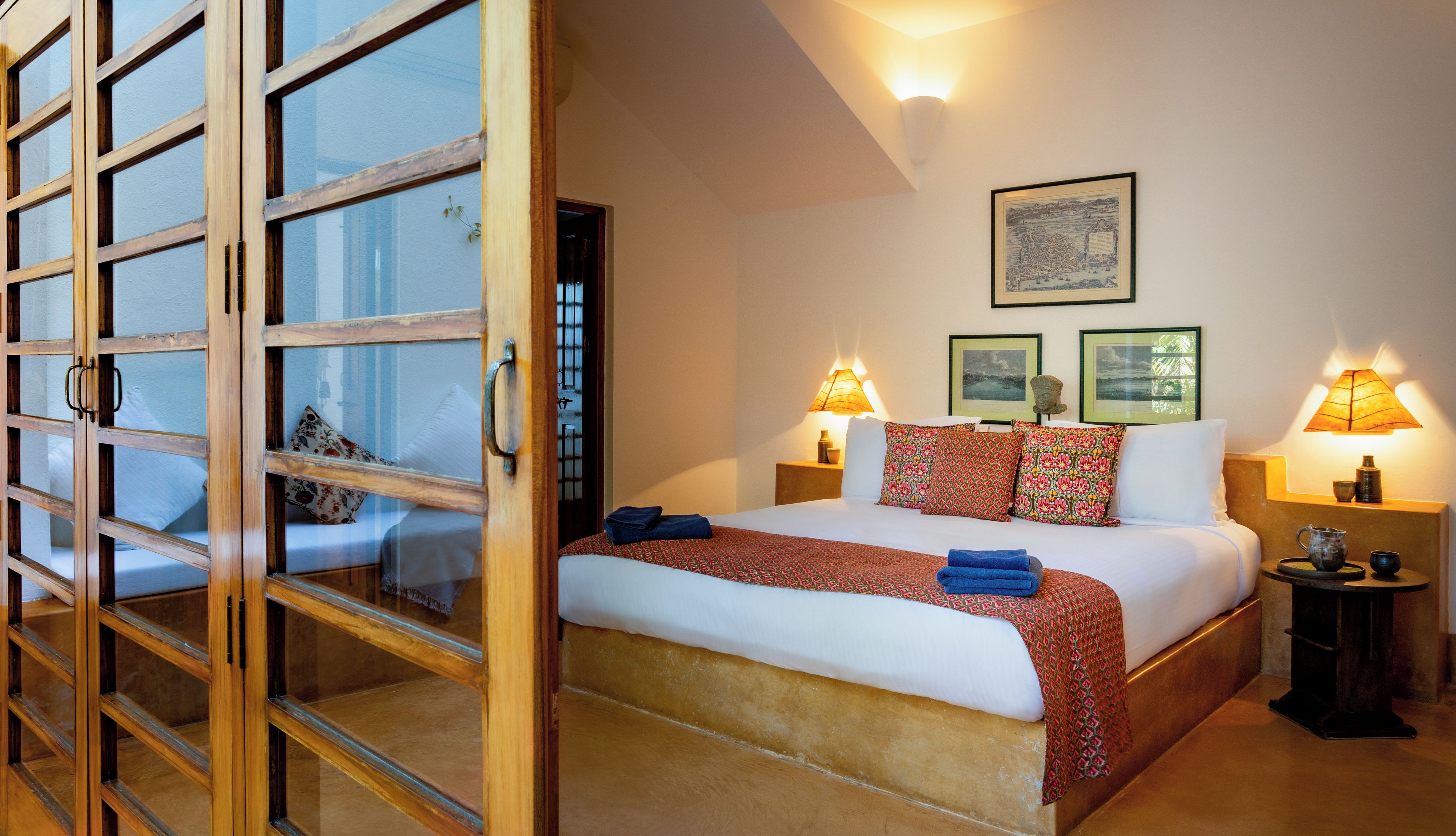 A hotel room with a bed, two bedside lamps, a nightstand, and a wall-mounted picture.