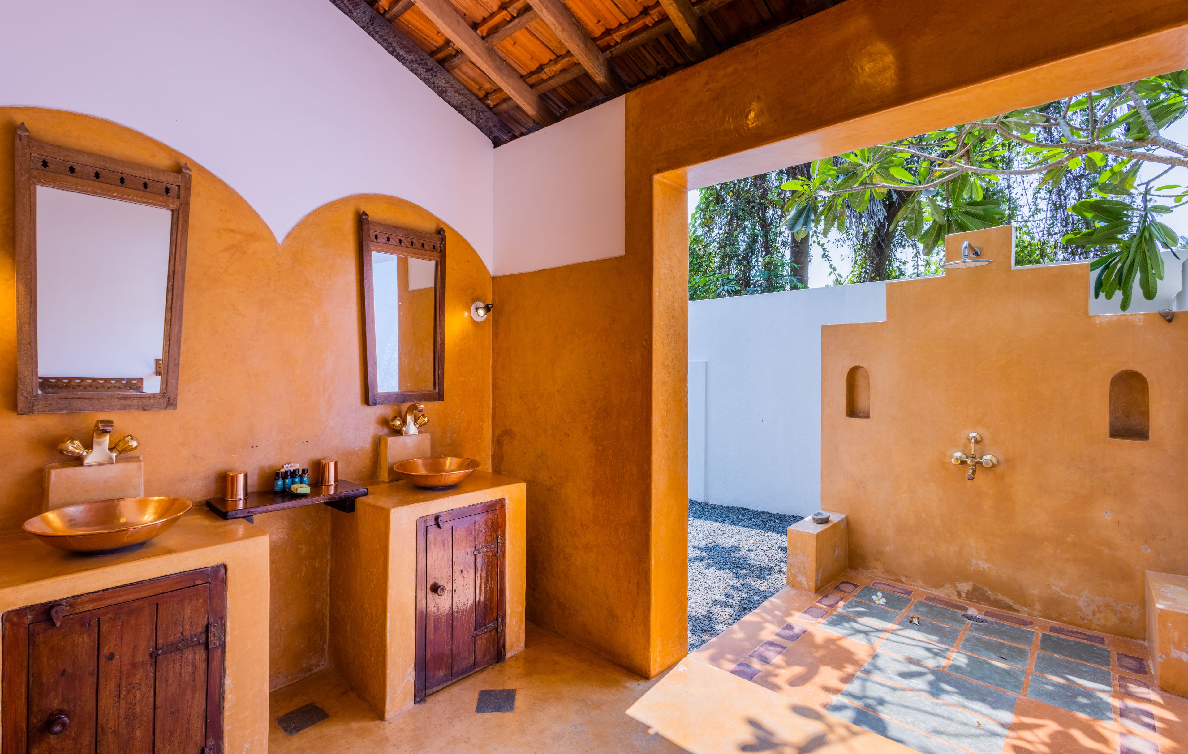 A bathroom with two sinks, a mirror, and a shower area.