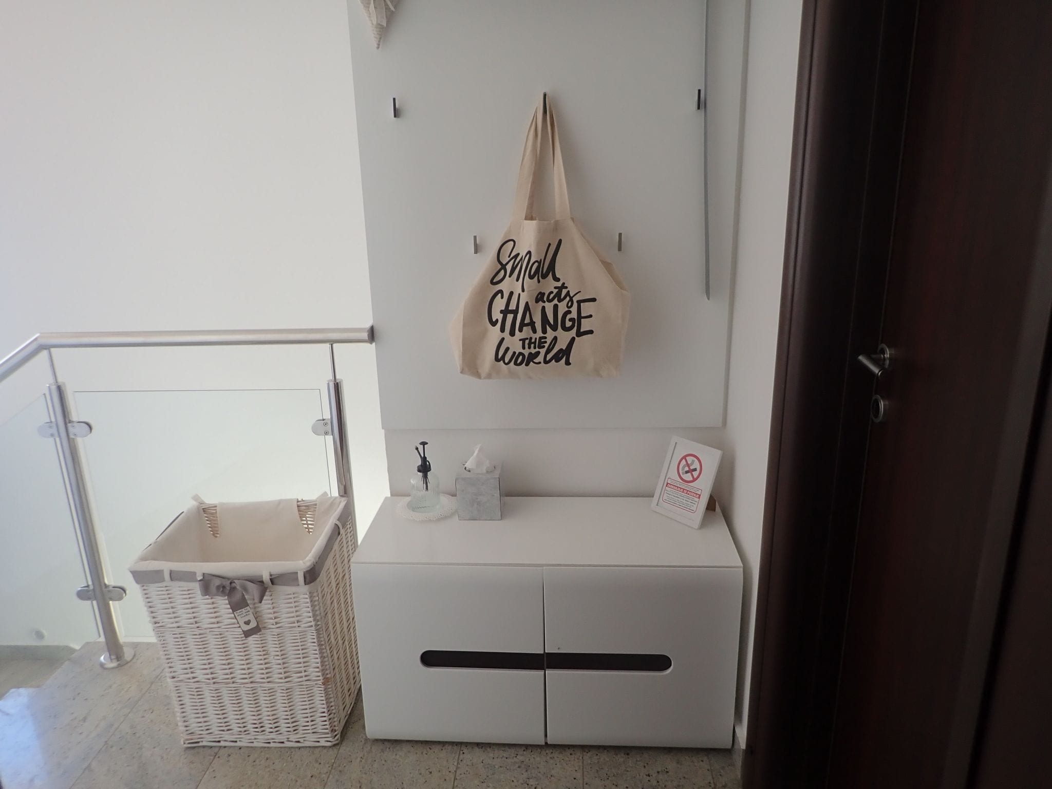 A clean, modern bathroom with a white vanity, a hanging towel, and a motivational quote on the wall.