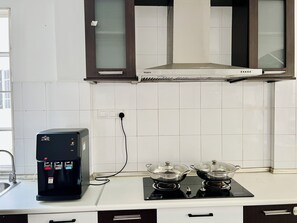 A kitchen with a coffee machine, two electric stoves, and a range hood.