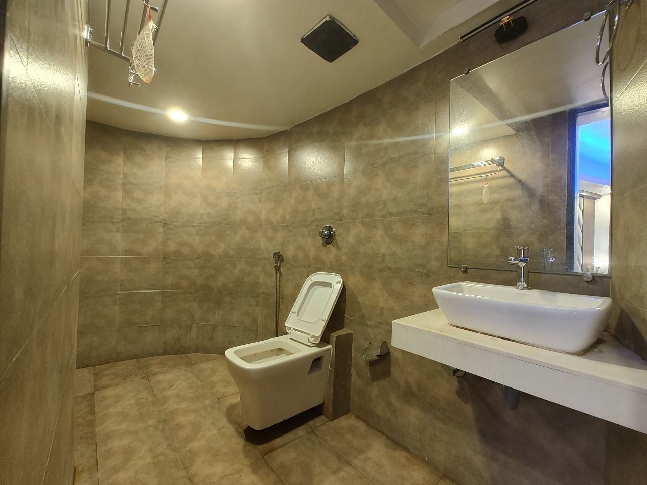 Un baño moderno con inodoro, lavabo y ducha.