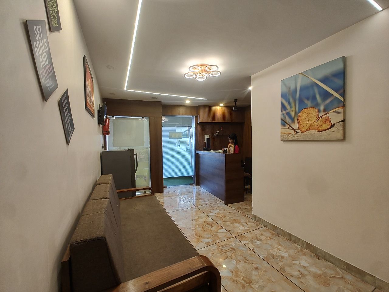 Un pasillo con una mesa de recepción, un banco de madera y un cuadro en la pared.