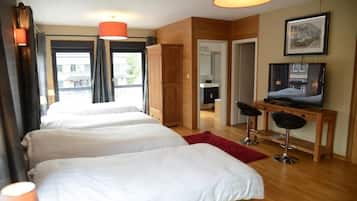 Ein Hotelzimmer mit zwei Betten, einem Schreibtisch, einem Fernseher und Blick ins Freie.