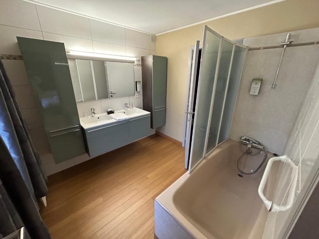 Un baño con bañera, lavabo y espejo.