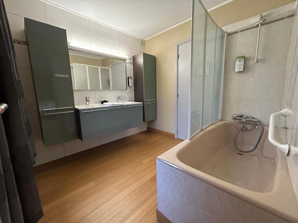 Un baño con bañera, lavamanos y espejo.