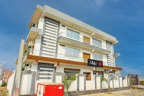 Um hotel de vários andares com design moderno, com varandas e grandes janelas.