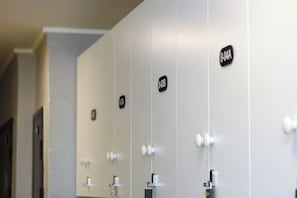 A row of restroom stalls with individual door handles and a sign above each stall.