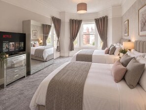 Une chambre d’hôtel avec deux lits, une télévision et une grande fenêtre.