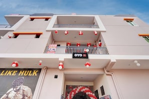 A hotel with a modern facade, balconies with railings, and a sign indicating the hotel name.