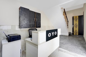 Un comptoir d'accueil avec une enseigne indiquant « OYO », dans un bureau moderne.