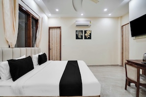 Une chambre d’hôtel équipée d’un lit, d’une télévision, d’un climatiseur et d’une porte.