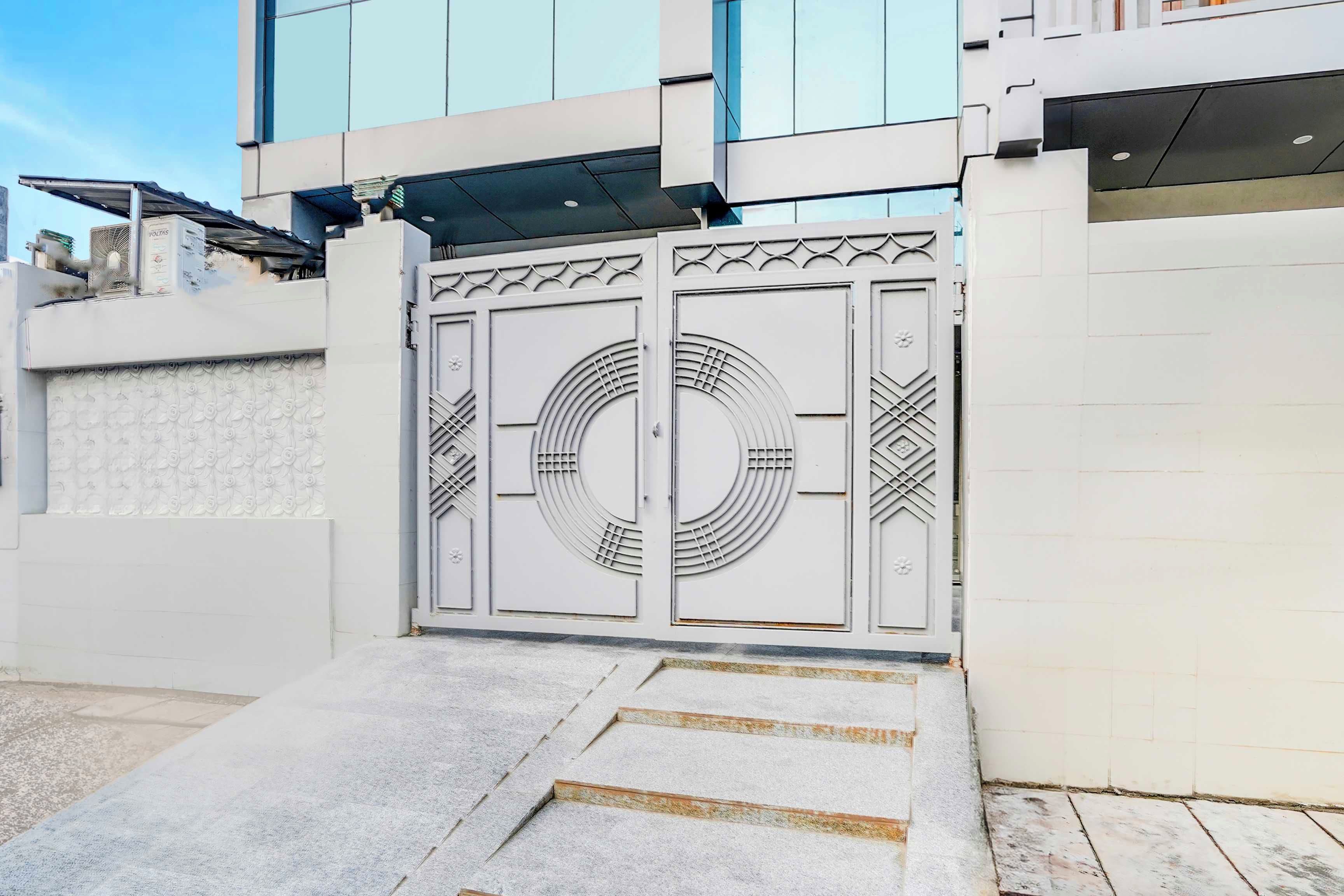 Une entrée fermée par un portail au design moderne, caractérisée par des motifs géométriques et un motif circulaire central.