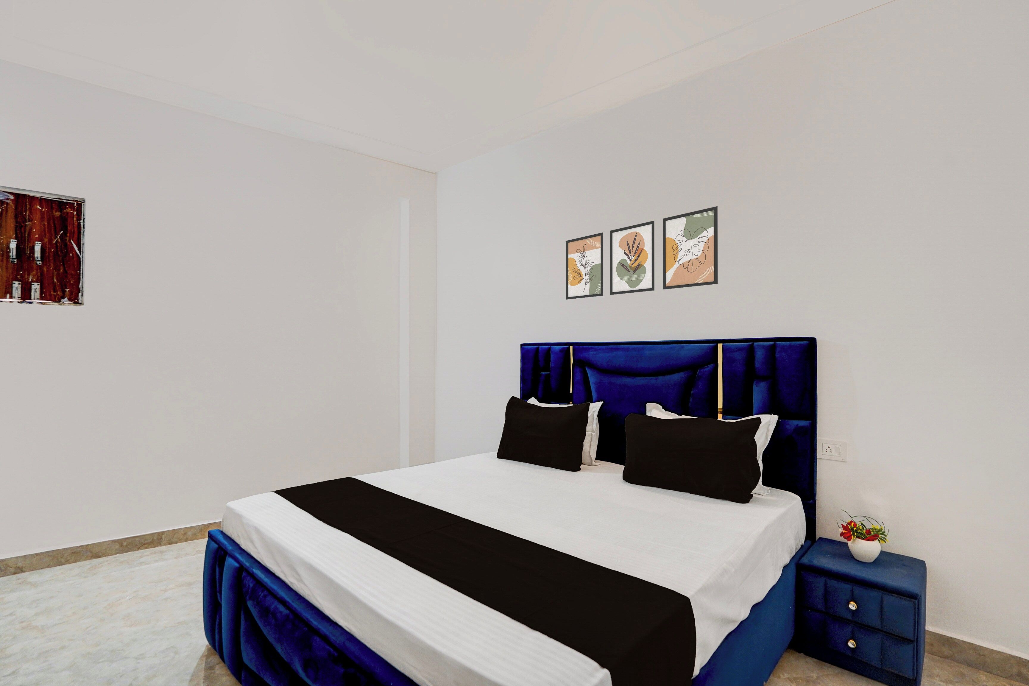 Un dormitorio con una cama grande, una mesita de noche y una estantería en la pared.