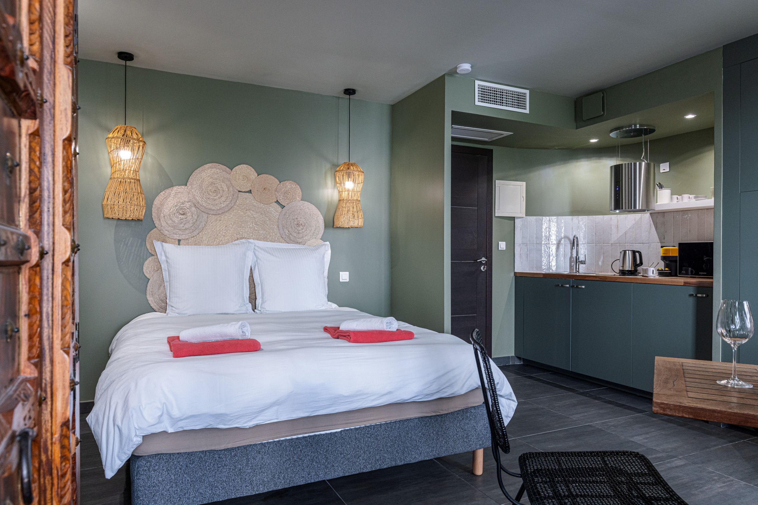 Una camera d'albergo con un letto, angolo cottura e zona pranzo.