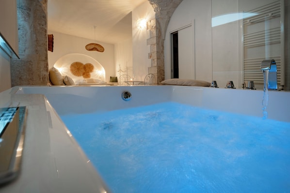 A modern bathroom with a large bathtub, a shower, and a sink. - Piazza Vecchia SUITE & SPA (Castellana Grotte)