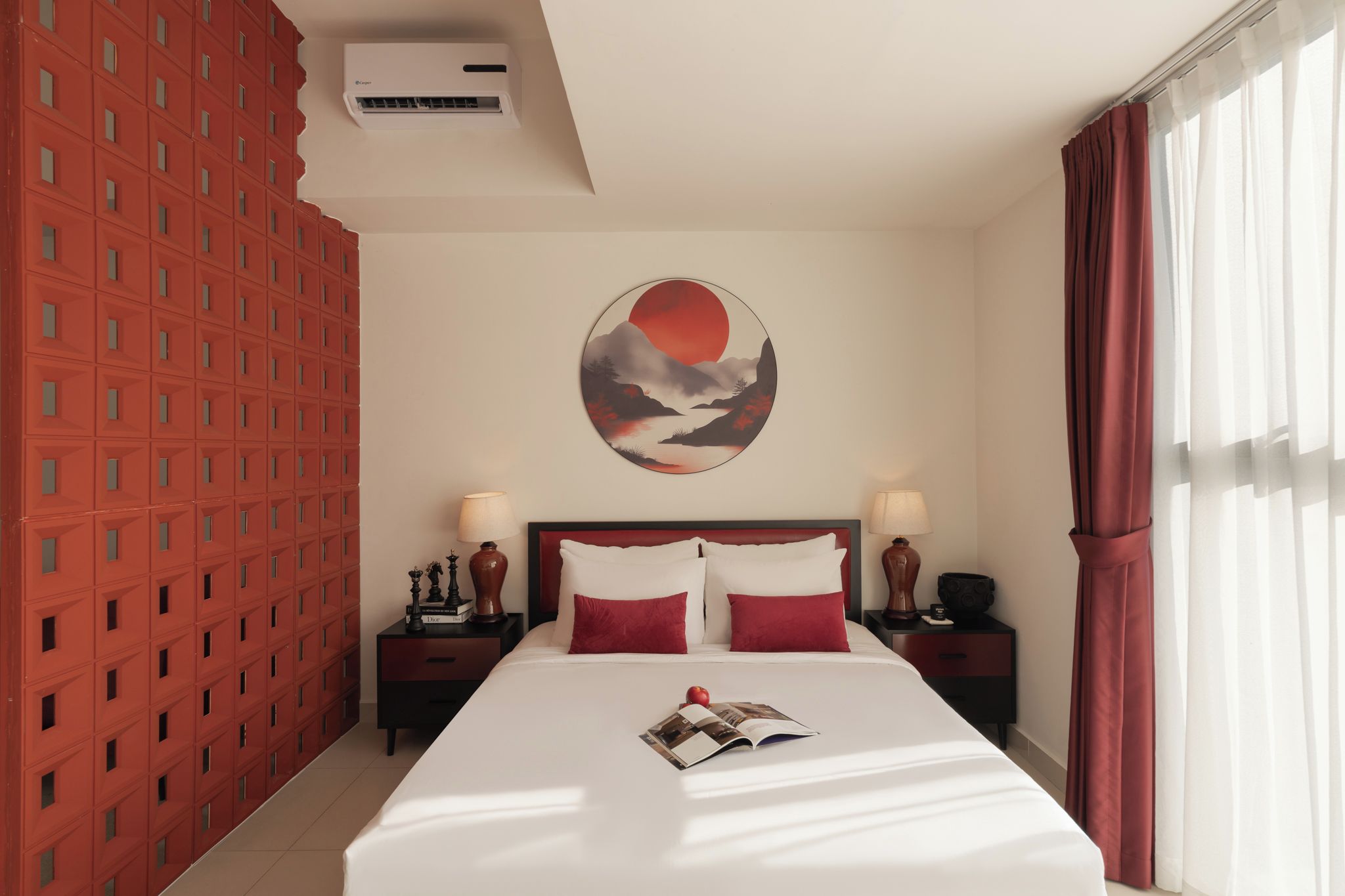 Una camera d'albergo con un letto grande, due comodini, un condizionatore d'aria a parete e una finestra con tende.