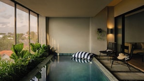 Una piscina interior moderna amb vista a l'horitzó urbà a través de grans finestres.
