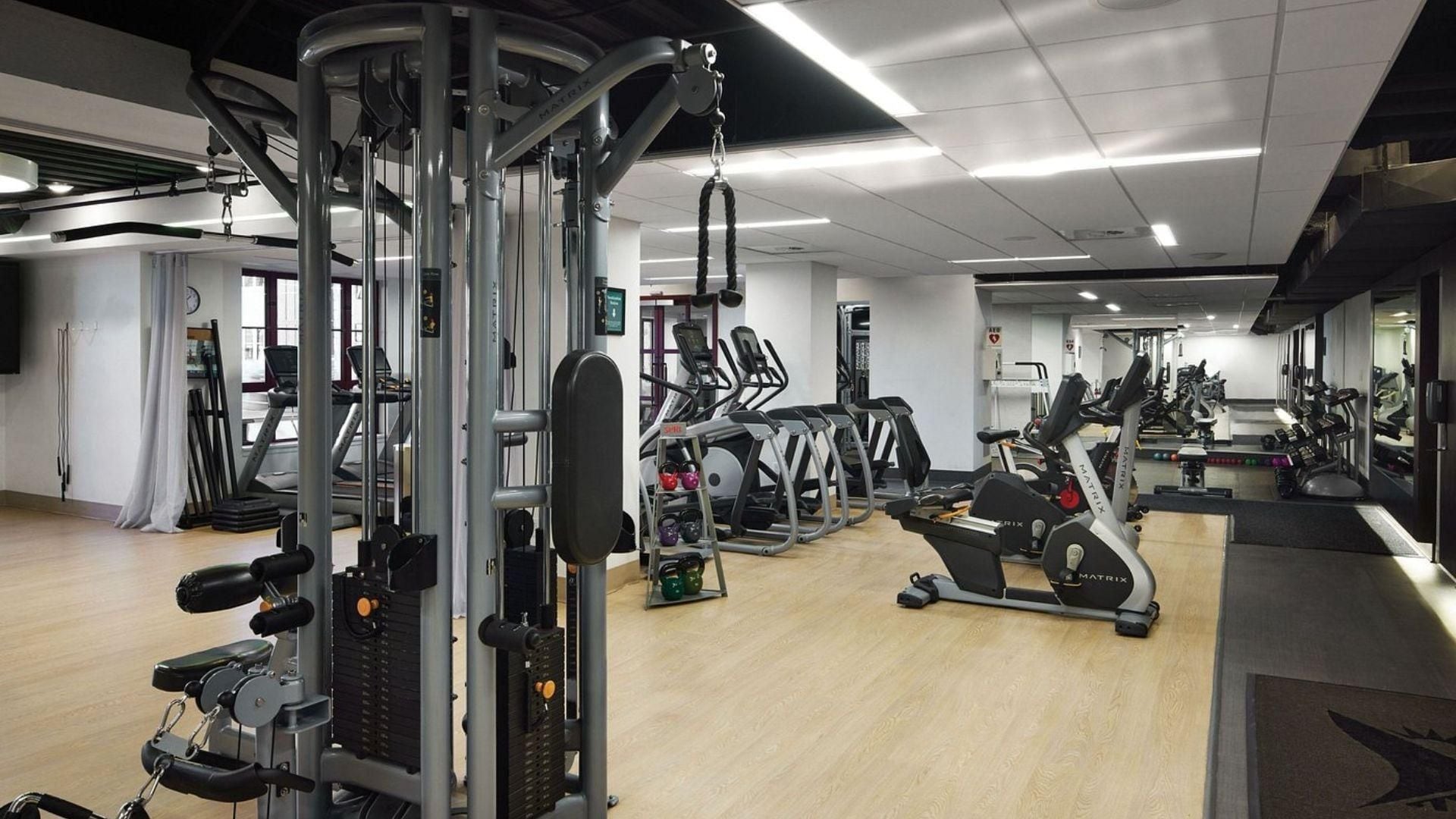 Une salle de sport équipée de divers appareils d’exercice, notamment des tapis de course et des appareils de musculation.