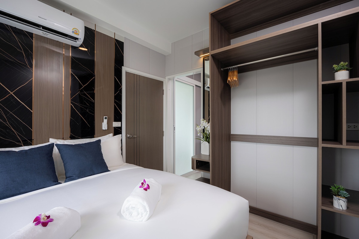 Ein Hotelzimmer mit Bett, Kleiderschrank und integrierter Klimaanlage.