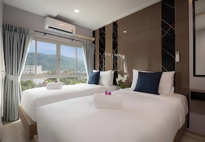Ein Hotelzimmer mit zwei Betten, einer Klimaanlage, Bergblick und modernem Design.