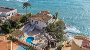 A coastal property with a swimming pool, a staircase leading to a terrace, and a view of the sea. - Spectacular 5BR Mediterranean Oceanfront Villa - Private Pool & Stunning Views (El Camplello)