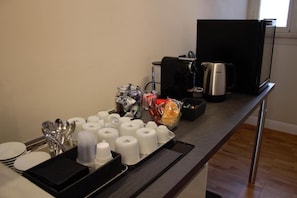 Habitación de hotel con kitchenette, que incluye cafetera, hervidor y microondas.