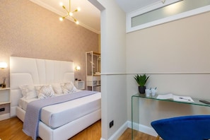A modern bedroom with a bed, bedside tables, a glass shelf with toiletries, and a shower area. - 52 Vespasiano Vatican Suites (Roma)