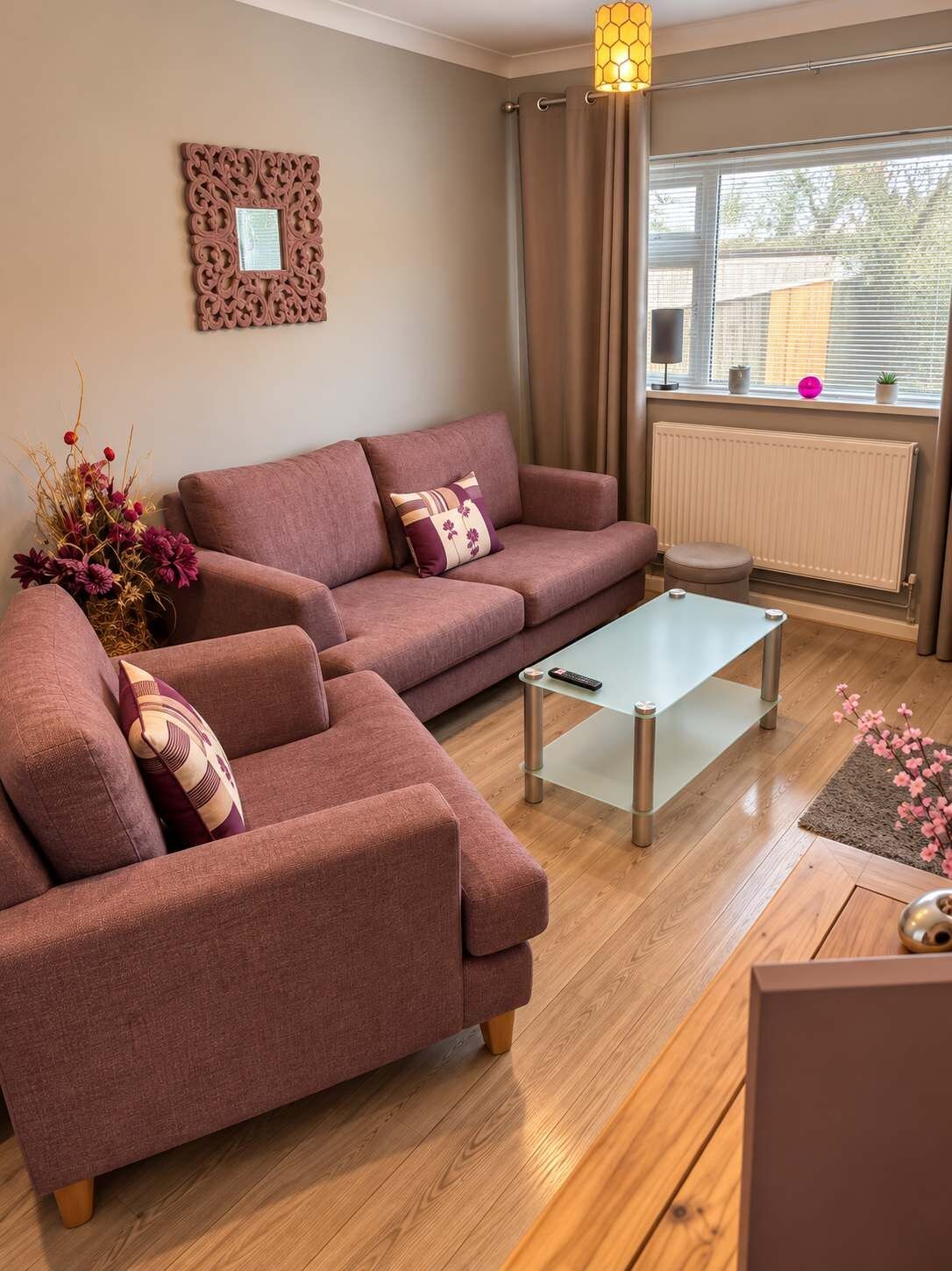 A living room with a sofa set, a coffee table, a radiator, and a window with curtains.