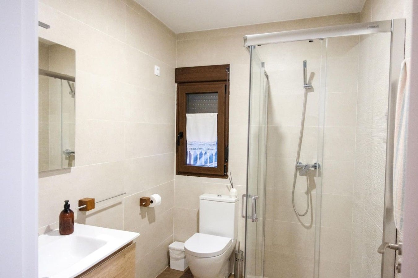 Een badkamer met douche, toilet en wastafel.