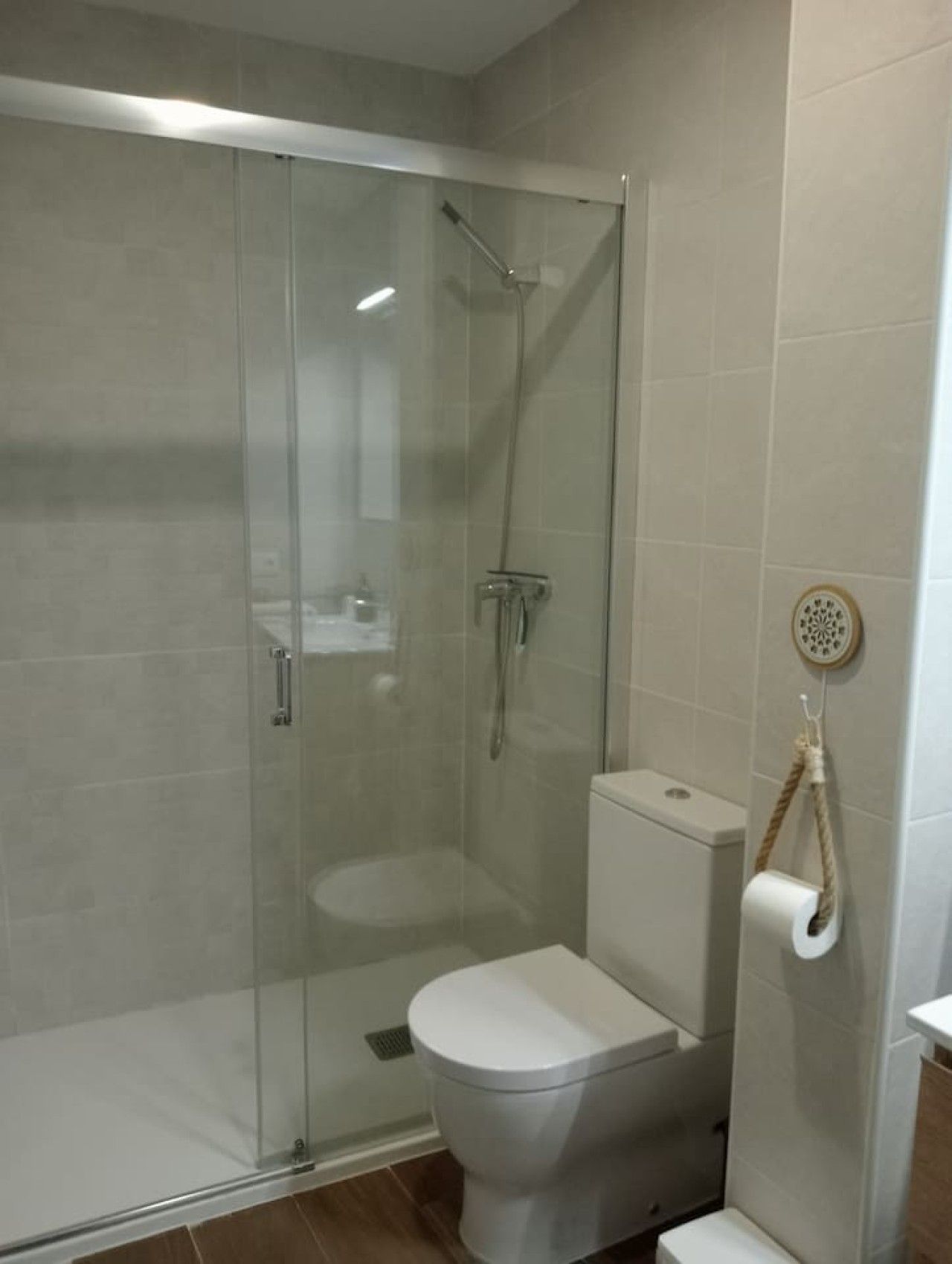 Ein Badezimmer mit einer Duschkabine, einer Toilette und einem Handtuchhalter.