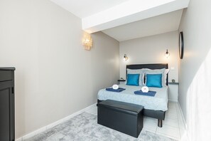 Ein Schlafzimmer mit einem Bett, Nachttischen, einer Bank und einem Kleiderschrank.