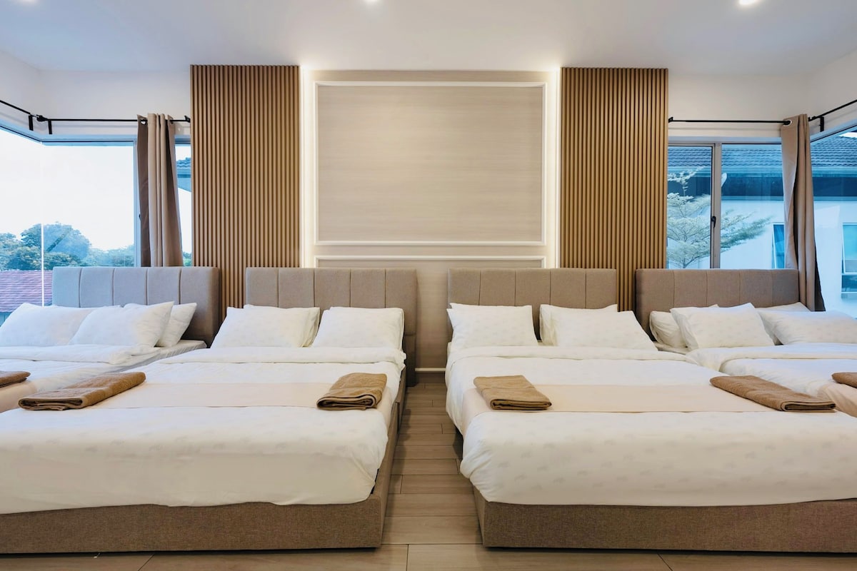 A hotel room with two beds, a large window, and a view of the outside.