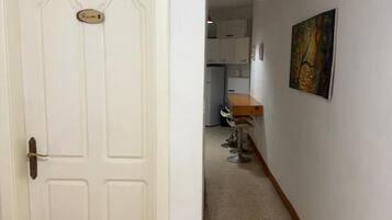 Un pasillo que conduce a una habitación con una puerta blanca marcada 'Room 2'.