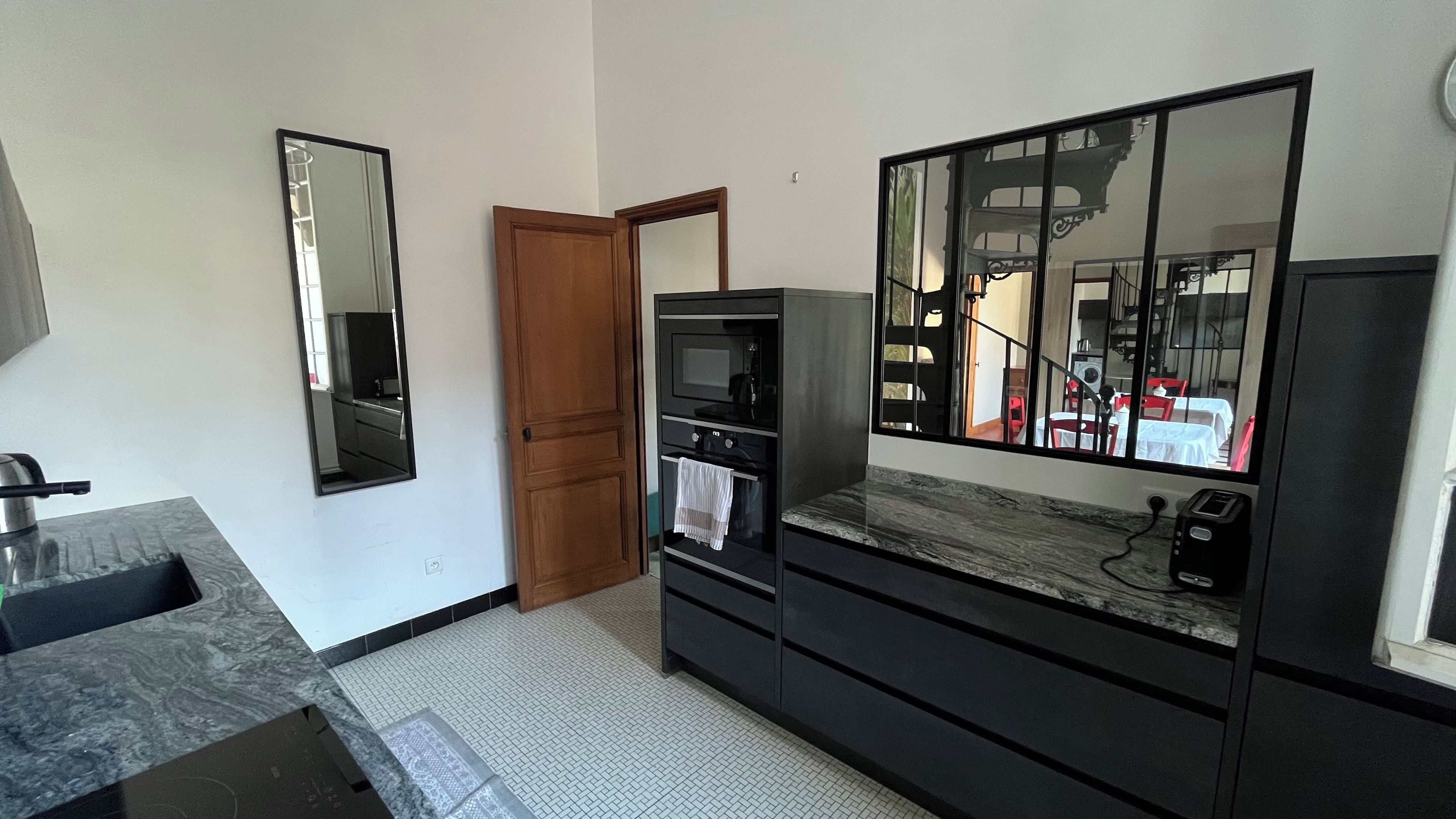 Een badkamer met een wastafel, spiegel en douchegedeelte.
