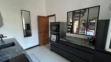 Een badkamer met een wastafel, spiegel en douchegedeelte.