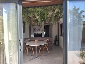 An open-plan living space with a dining area, a sofa, and hanging plants. - New Listing (Vergèze)