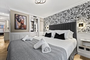 Ein modernes Schlafzimmer mit einem großen Bett, einer Wand mit Muster und einem Gemälde.