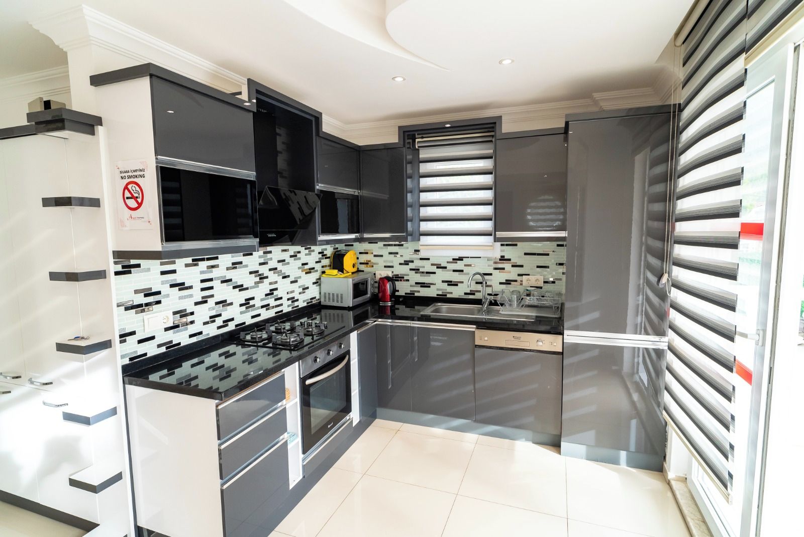 A modern kitchen with black cabinets, a microwave, a stove, and a dishwasher.