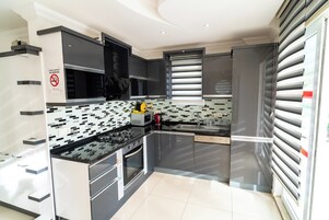 Una cocina moderna con armarios negros, microondas, estufa y lavavajillas.